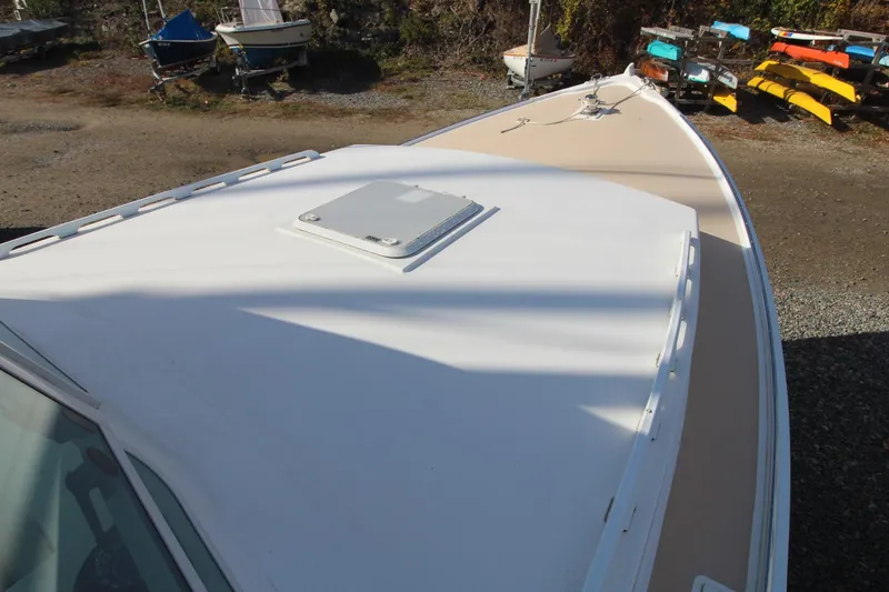 Slide: The Image of Bow view of a 2020 Holland 32 boat, docked with kayaks in the background. - 11