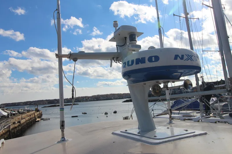 Slide: The Image of Radar equipment on a 2020 Holland 32 boat, docked by a scenic waterfront. - 15