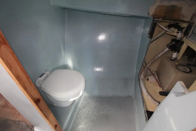 Slide: The Image of Compact marine bathroom in a 2020 Holland 32 boat, featuring a toilet and storage area. - 23