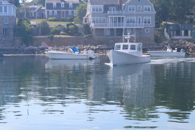 Slide: The Image of Boats on calm water near coastal houses, featuring a 2020 Holland 32 model. - 28
