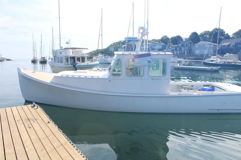 Slide: The Image of 2020 Holland 32 boat docked in a marina with sailboats and waterfront houses. - 3