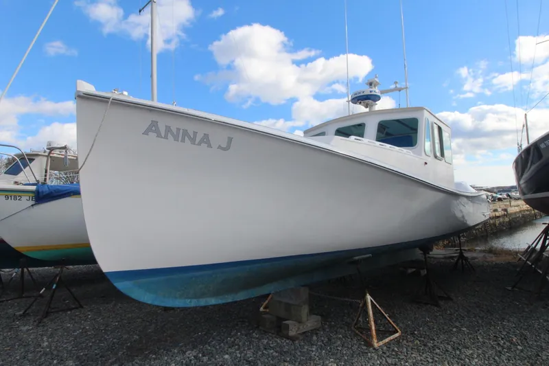 Slide: The Image of Holland 32 boat named "Anna J" on land, 2020 model, under a blue sky. - 5