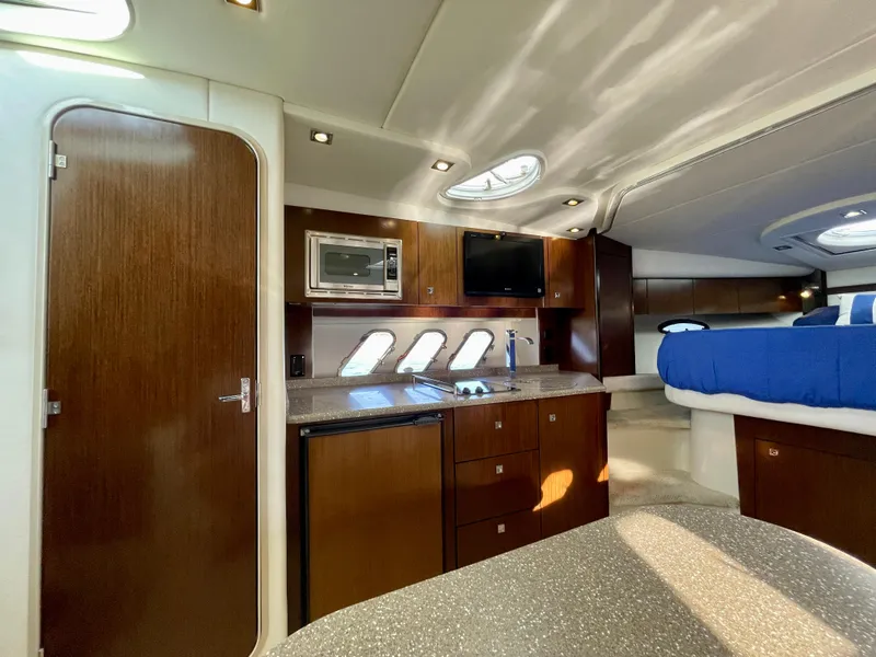 Slide: The Image of Luxurious interior of 2012 Cruisers Yachts 35 Express with kitchenette and sleeping area. - 14