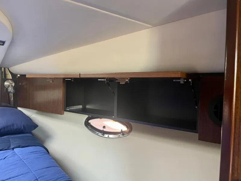 Slide: The Image of 2012 Cruisers Yachts 35 Express cabin interior with storage and porthole. - 22