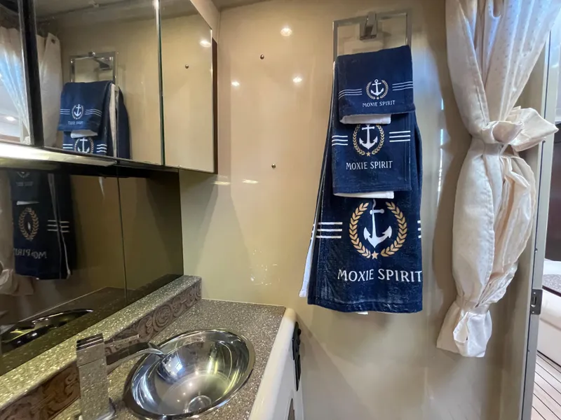 Slide: The Image of 2012 Cruisers Yachts 35 Express bathroom with nautical-themed towels and modern sink. - 25