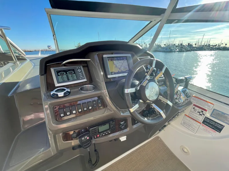 Slide: The Image of Helm of 2012 Cruisers Yachts 35 Express with navigation equipment and steering wheel, overlooking marina. - 27