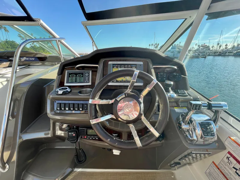 Slide: The Image of 2012 Cruisers Yachts 35 Express helm with steering wheel and control panel, docked in marina. - 28