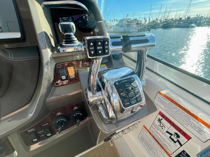 Slide: The Image of Control panel of 2012 Cruisers Yachts 35 Express with throttle and joystick, overlooking marina. - 29