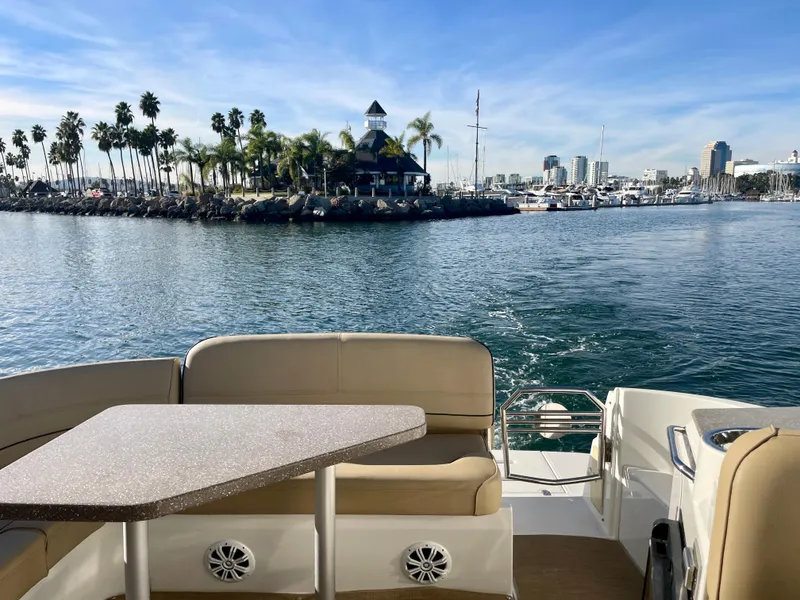 Slide: The Image of 2012 Cruisers Yachts 35 Express on water, scenic harbor view, palm trees, and city skyline. - 33