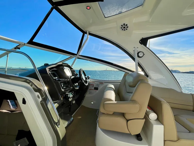 Slide: The Image of Interior view of 2012 Cruisers Yachts 35 Express, featuring helm and seating with ocean backdrop. - 42
