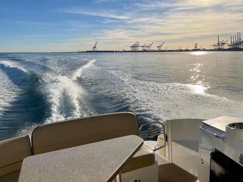 Slide: The Image of 2012 Cruisers Yachts 35 Express cruising on calm waters near industrial port. - 46