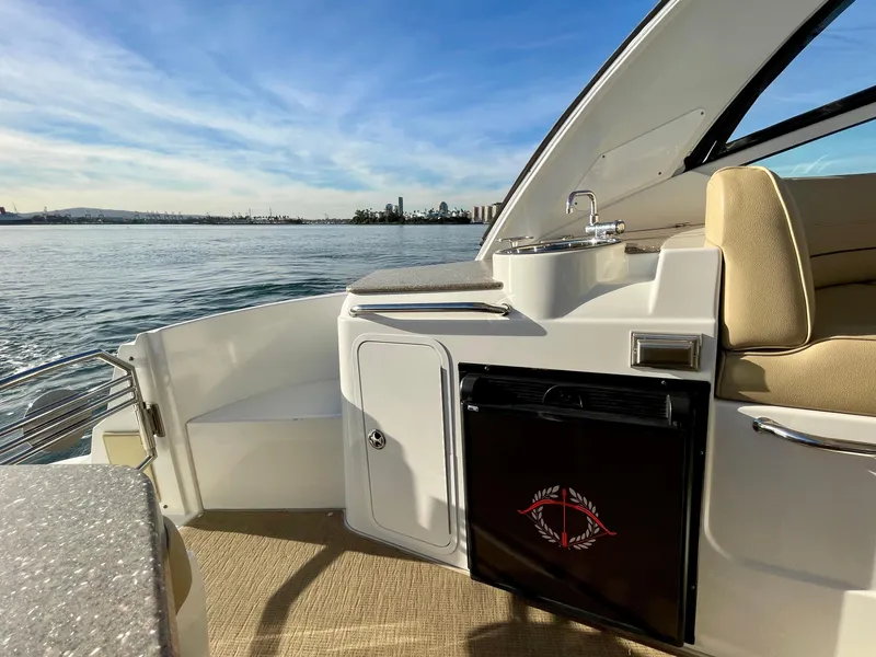 Slide: The Image of 2012 Cruisers Yachts 35 Express interior with seating, sink, and mini fridge, overlooking serene waters. - 48
