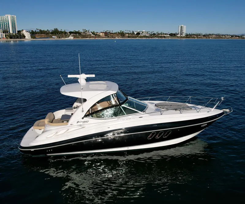 Slide: The Image of 2012 Cruisers Yachts 35 Express on calm ocean waters, city skyline in background. - 7