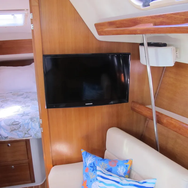 Slide: The Image of Interior of 2007 Catalina 387 yacht with TV, sofa, and colorful pillows. - 26
