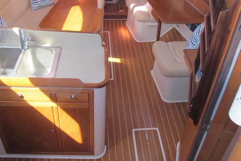 Slide: The Image of Interior of 2007 Catalina 387 sailboat with wood flooring and compact kitchen area. - 28