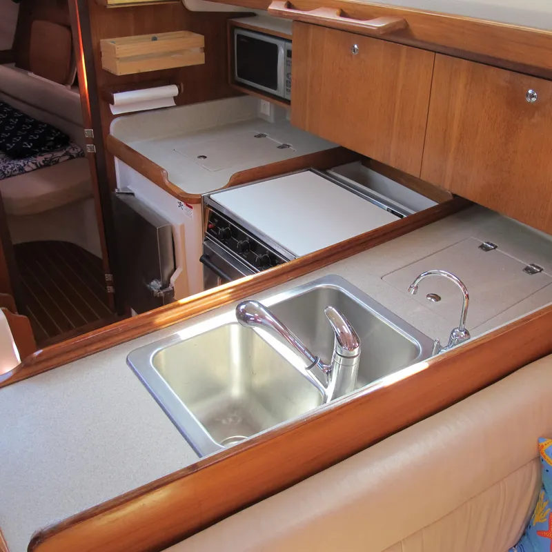 Slide: The Image of 2007 Catalina 387 yacht kitchen with sink, stove, and wooden cabinetry. - 34