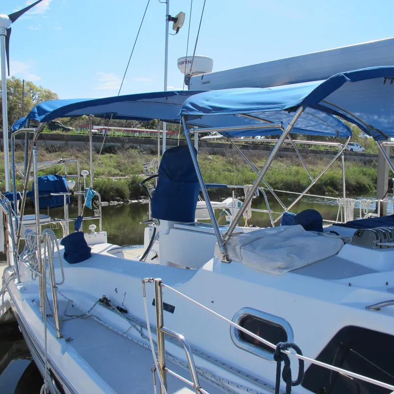 Slide: The Image of 2007 Catalina 387 sailboat with blue canopy docked at marina. - 5