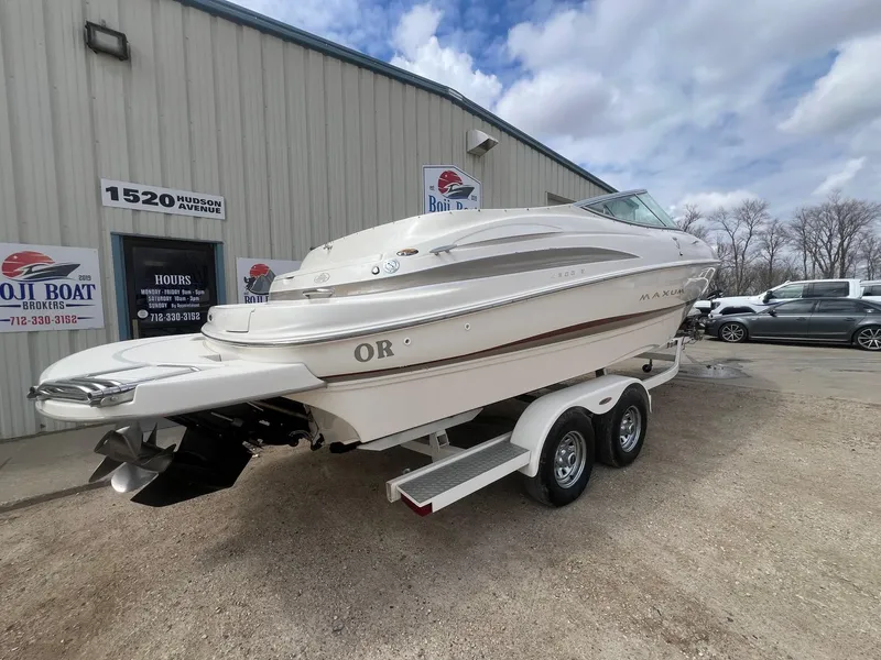 Slide: The Image of 2002 Maxum 2300 SR boat on trailer outside dealership, cloudy sky background. - 10