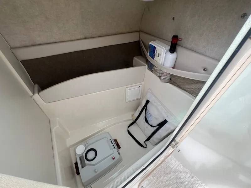 Slide: The Image of 2002 Maxum 2300 SR boat interior with storage and portable toilet. - 15