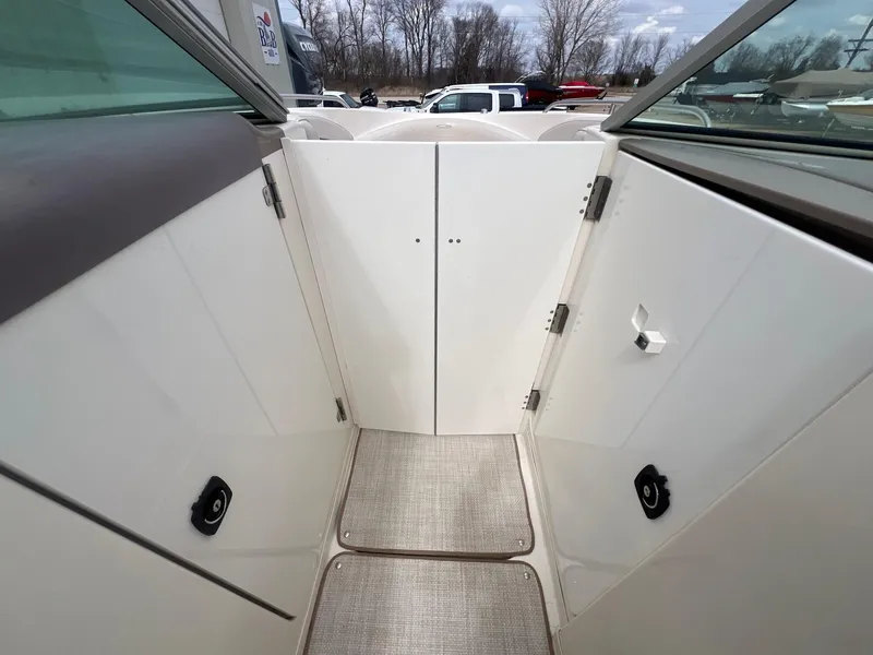 Slide: The Image of 2002 Maxum 2300 SR boat interior with white panels and carpeted flooring. - 16