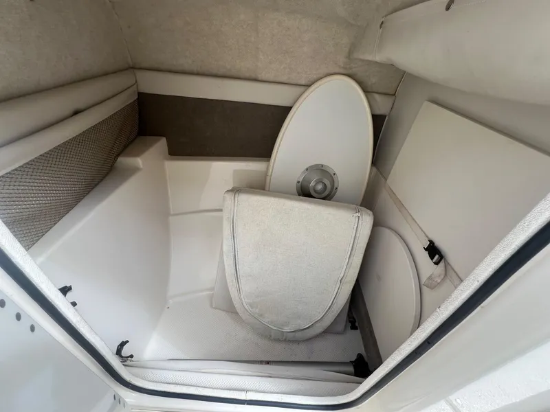 Slide: The Image of 2002 Maxum 2300 SR boat interior storage compartment with seating and table components. - 17