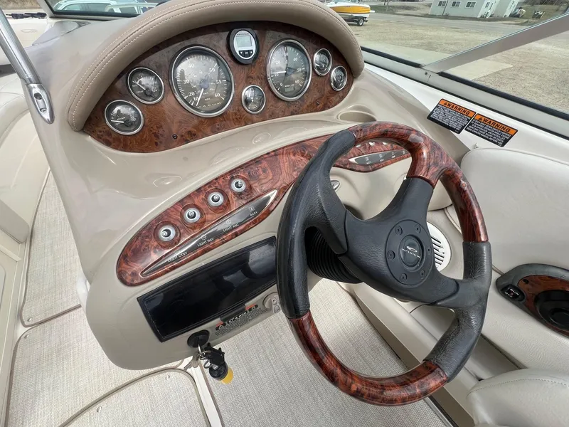 Slide: The Image of 2002 Maxum 2300 SR boat dashboard with wood accents and steering wheel. - 18