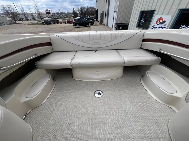 Slide: The Image of 2002 Maxum 2300 SR boat interior with beige seating and carpeted floor. - 23