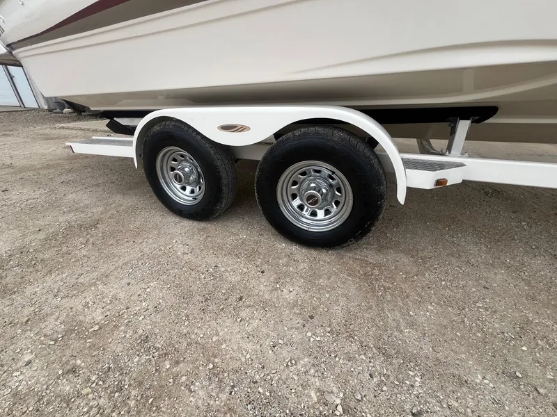 Slide: The Image of Trailer wheels of a 2002 Maxum 2300 SR boat on gravel surface. - 32
