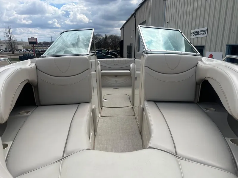Slide: The Image of 2002 Maxum 2300 SR boat interior with beige seating and open deck under cloudy sky. - 5