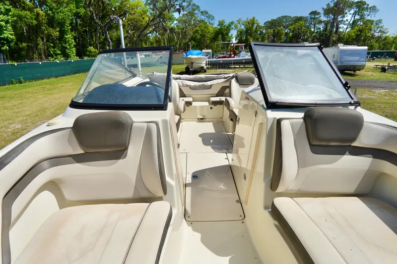 Slide: The Image of 2015 Yamaha Boats 242 Limited S interior with beige seating and open windshield. - 14