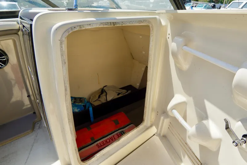 Slide: The Image of Storage compartment inside 2015 Yamaha Boats 242 Limited S, featuring life jackets and gear. - 28
