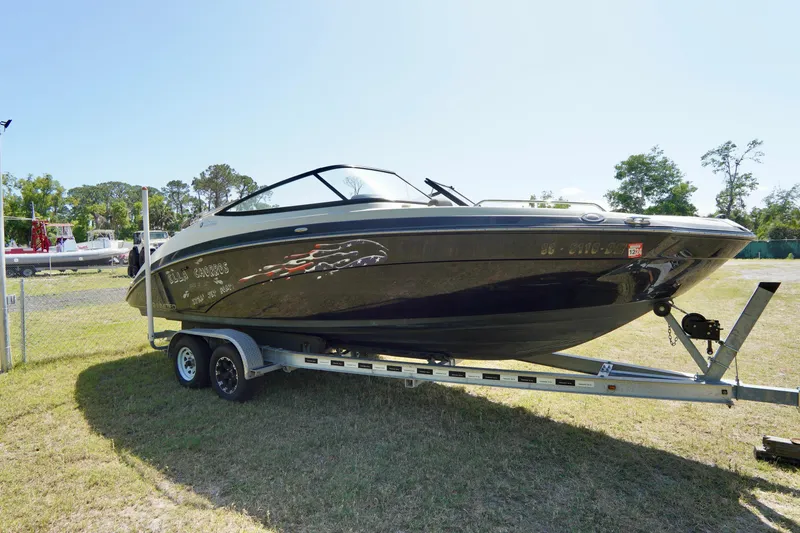 Slide: The Image of 2015 Yamaha Boats 242 Limited S on trailer, parked on grass under clear sky. - 3