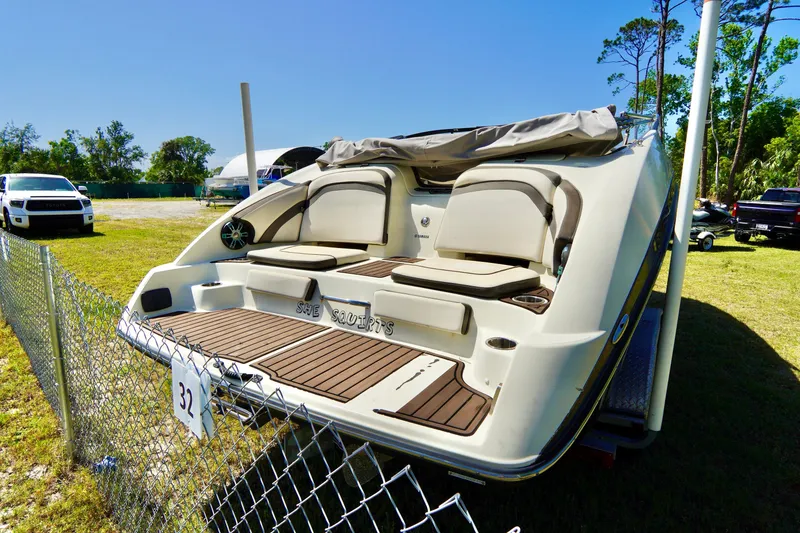 Slide: The Image of 2015 Yamaha Boats 242 Limited S, rear view, parked outdoors near a fence. - 31