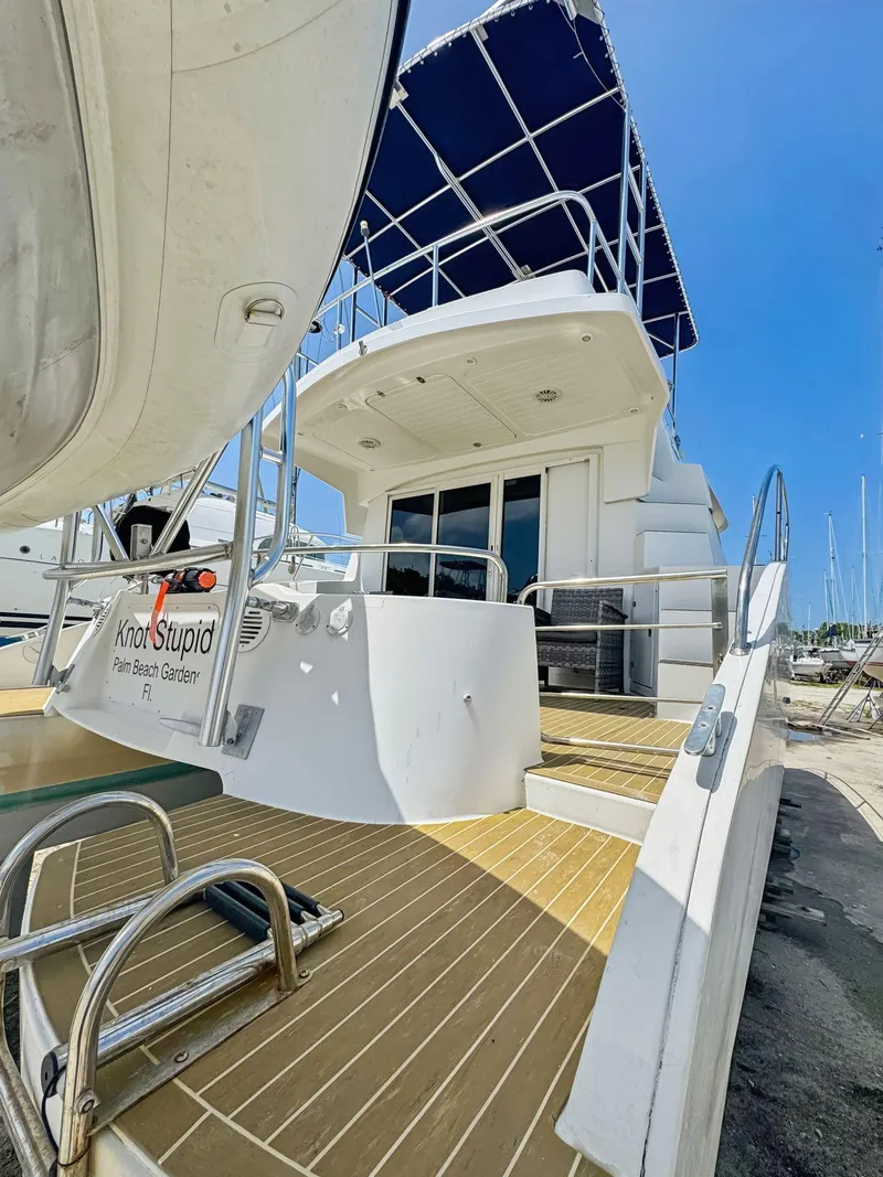 Slide: The Image of 2005 Fountaine Pajot HIGHLAND yacht with cushioned deck, docked under clear skies. - 17