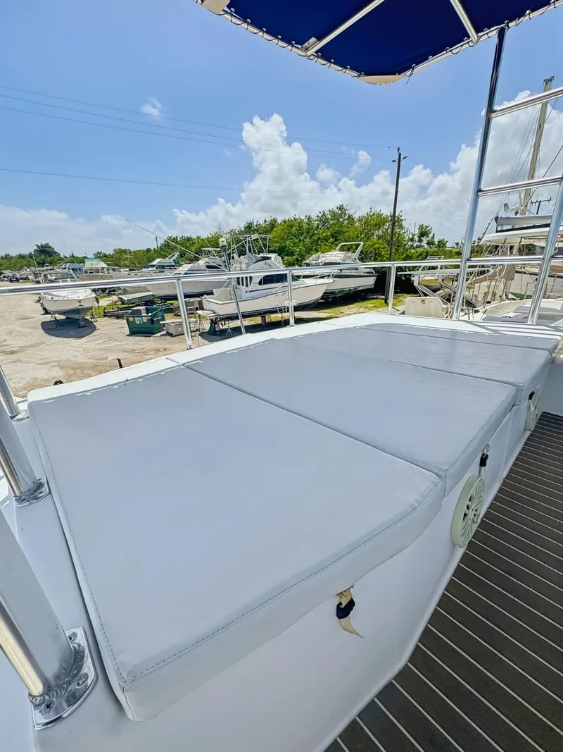 Slide: The Image of 2005 Fountaine Pajot HIGHLAND boat helm with blue canopy, docked under clear sky. - 20