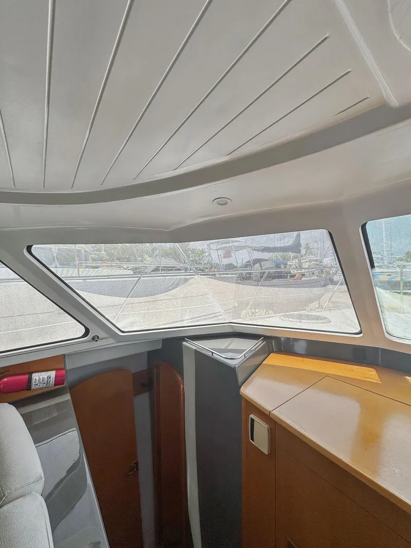 Slide: The Image of 2005 Fountaine Pajot HIGHLAND cabin interior with bed, wooden cabinetry, and wall-mounted TV. - 32