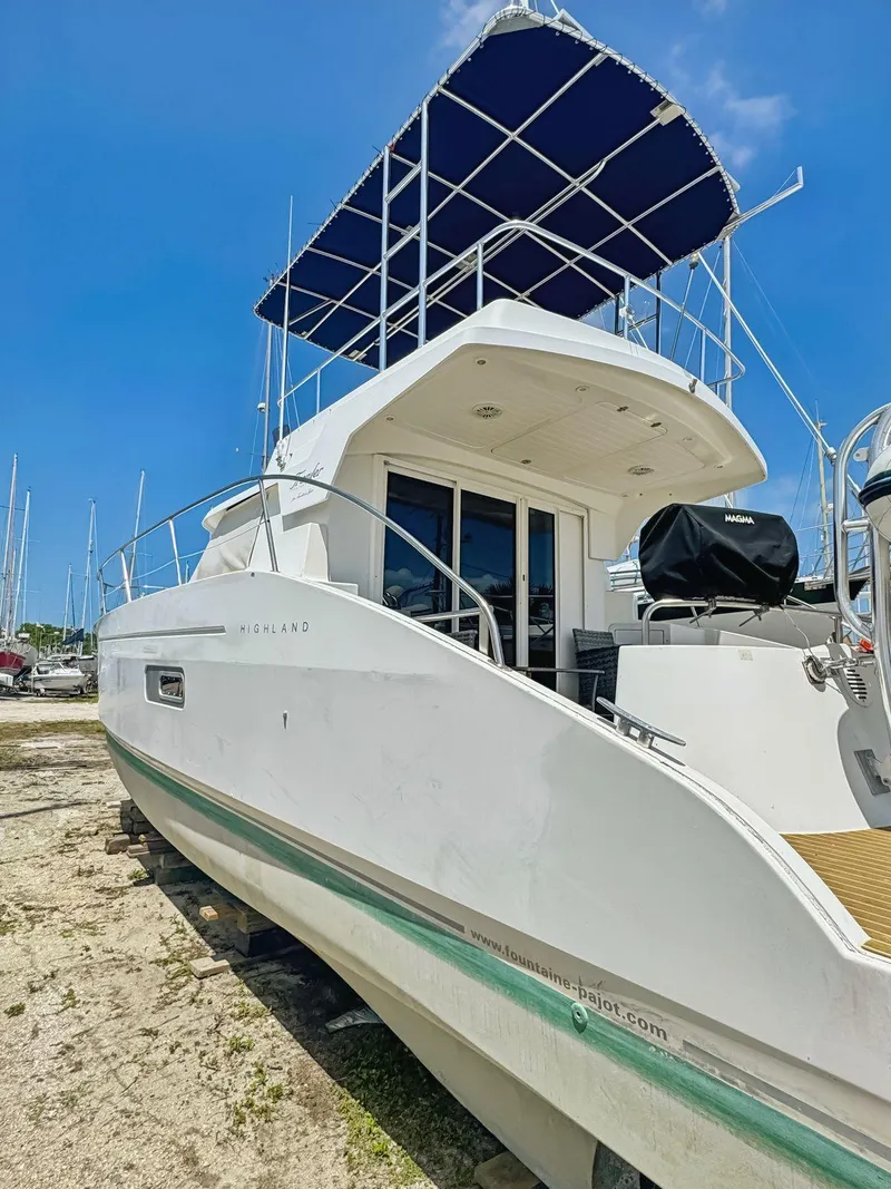 Slide: The Image of 2005 Fountaine Pajot HIGHLAND yacht with blue canopy, docked under clear sky. - 8