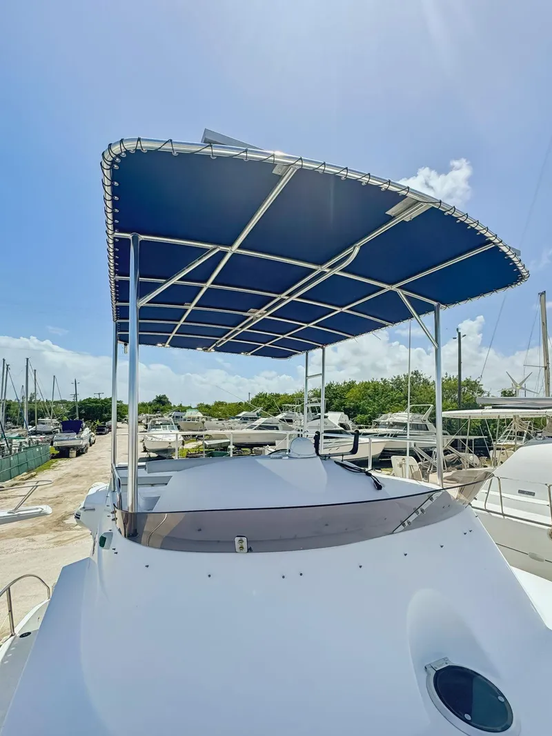 Slide: The Image of 2005 Fountaine Pajot HIGHLAND yacht deck with seating and table, docked in marina. - 13