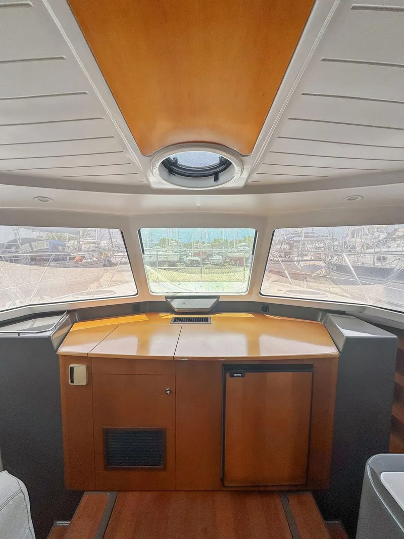 Slide: The Image of 2005 Fountaine Pajot HIGHLAND interior with cozy seating and wooden table. - 24