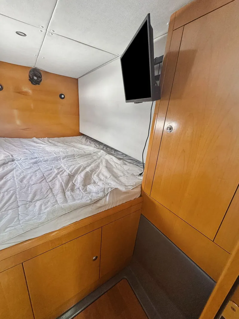 Slide: The Image of 2005 Fountaine Pajot HIGHLAND cabin interior with bed and wooden cabinetry. - 34