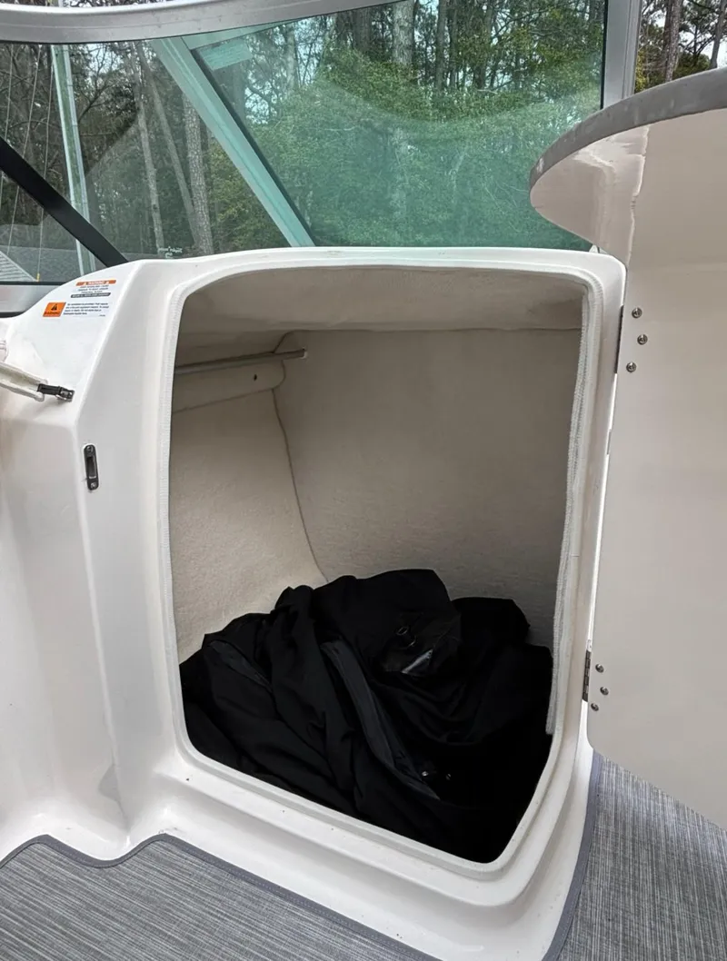 Slide: The Image of 2017 Chaparral 210 Suncoast boat storage compartment with black fabric inside. - 7