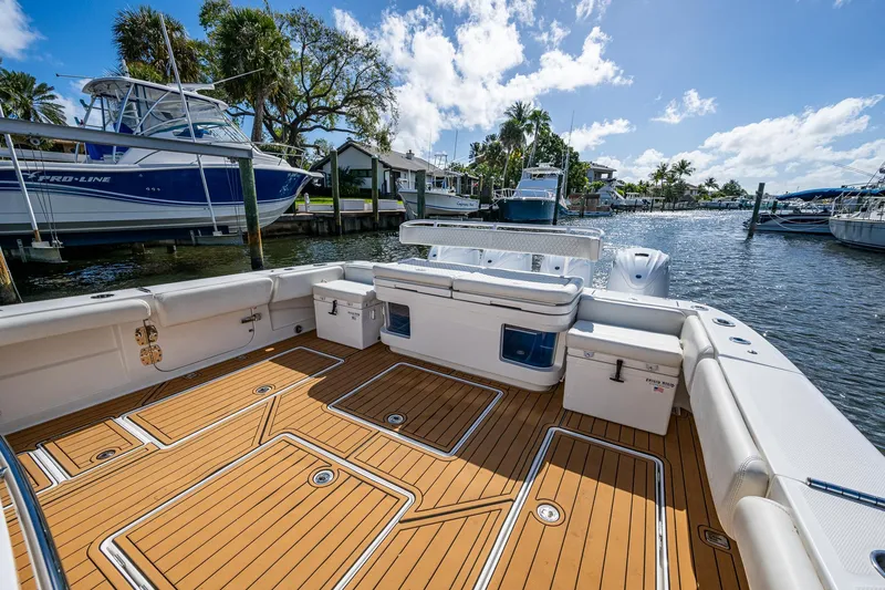 Slide: The Image of 2020 HCB 53 boat with spacious deck, docked in a sunny marina. - 5