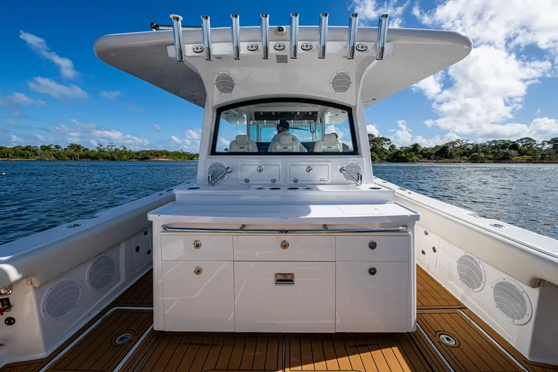 Slide: The Image of 2020 HCB 53 boat with spacious deck and modern amenities on a sunny day. - 6
