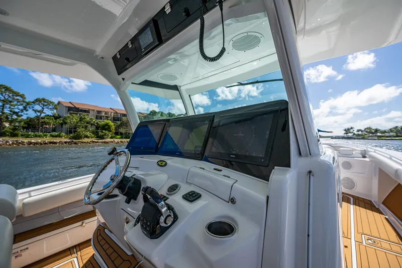 Slide: The Image of 2020 HCB 53 boat helm with modern controls and navigation screens on a sunny day. - 8