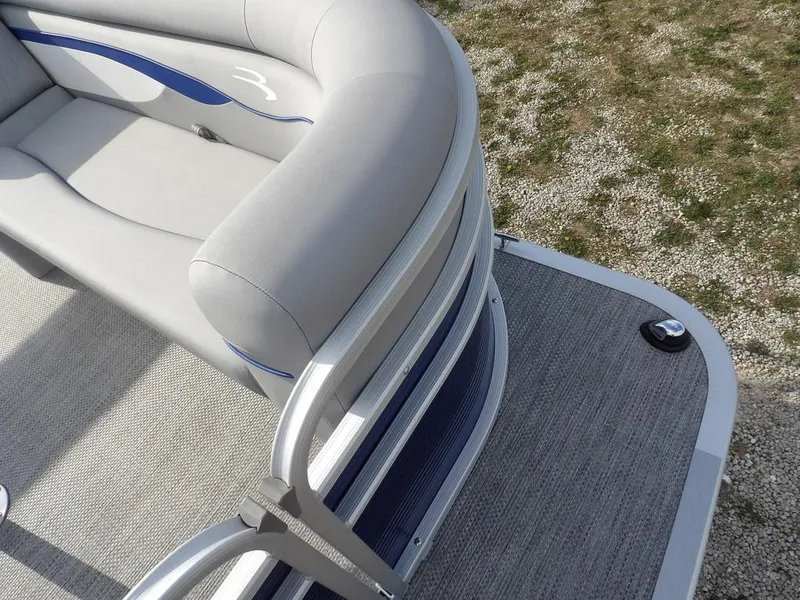 Slide: The Image of 2023 Bennington 20 SVSR pontoon boat with gray seating and blue accents on deck. - 10