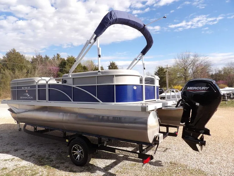 Slide: The Image of 2023 Bennington 20 SVSR pontoon boat with Mercury engine on trailer, outdoors. - 6