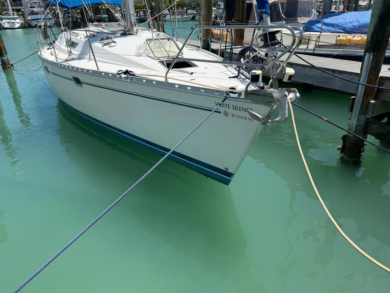 Slide: The Image of 1998 Jeanneau Sun Odyssey 42.2 sailboat docked in turquoise water. - 10