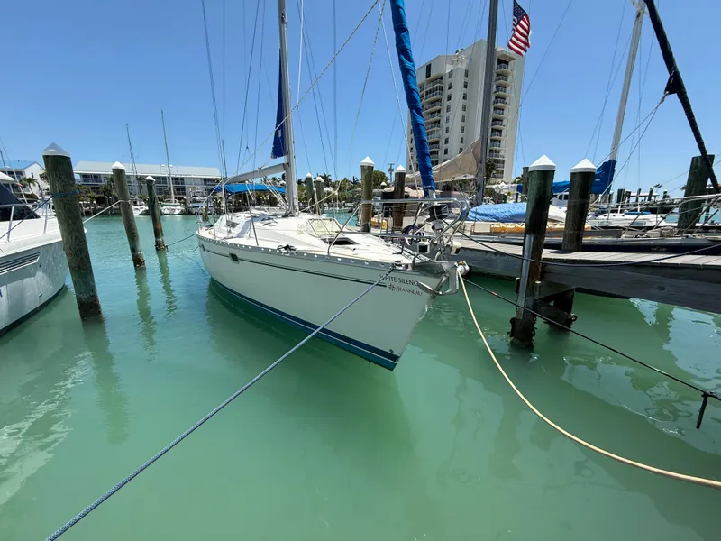 Slide: The Image of 1998 Jeanneau Sun Odyssey 42.2 sailboat docked in a marina with clear turquoise water. - 11