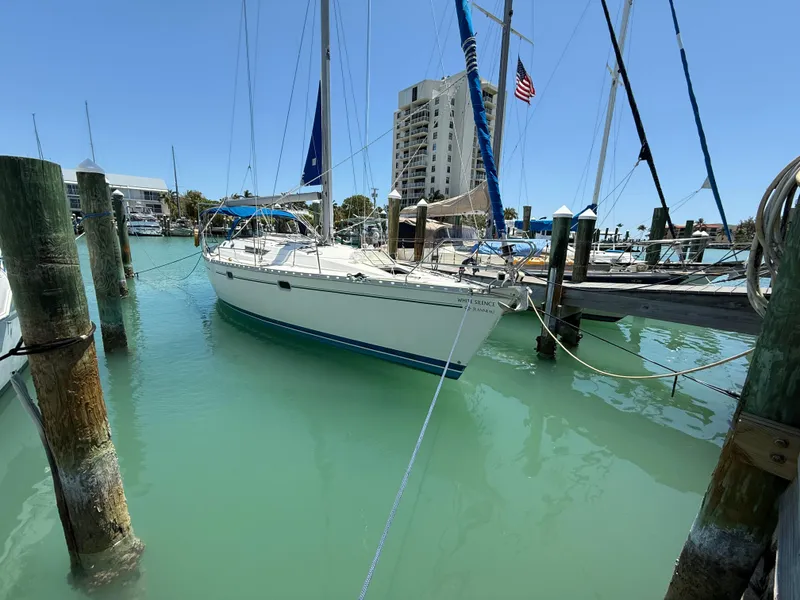 Slide: The Image of Sailboat Jeanneau Sun Odyssey 42.2, 1998, docked in a marina with turquoise water. - 13