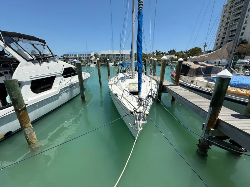 Slide: The Image of Sailboat Jeanneau Sun Odyssey 42.2, 1998, docked in a marina with turquoise water. - 14
